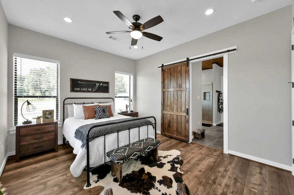 Conroe Ranch Style Barndominium Home Builder with master bedroom and barn door